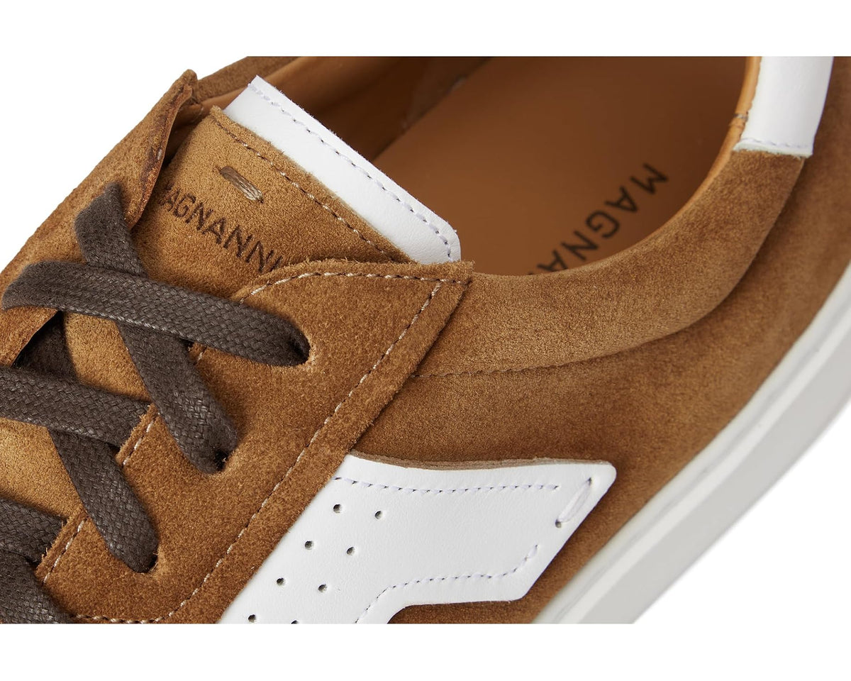 Men's suede sneaker close-up, cognac suede with white trim and lace eyelets