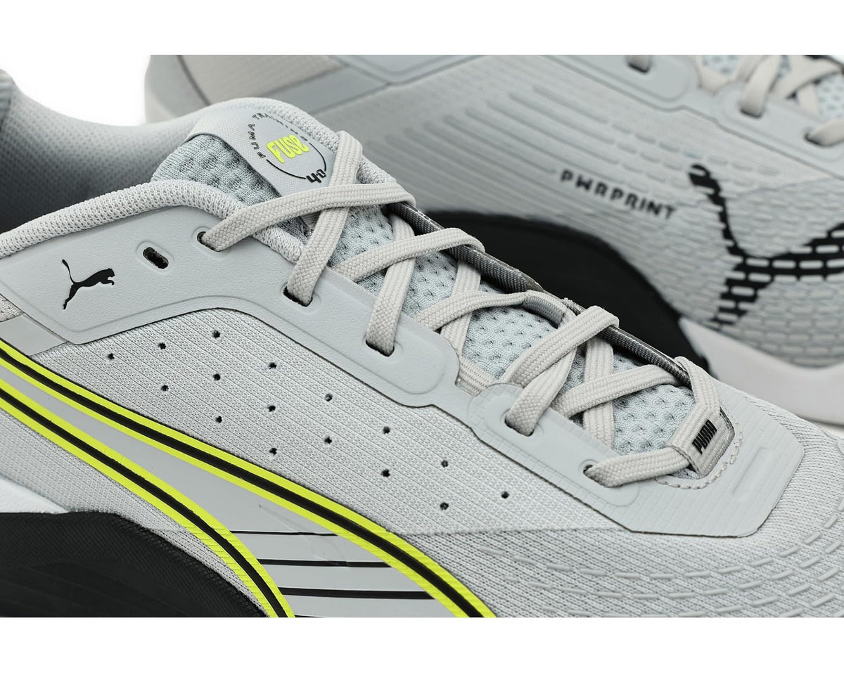 Close-up of light gray cross training shoe with laces, PUMA logo, and neon stripe.