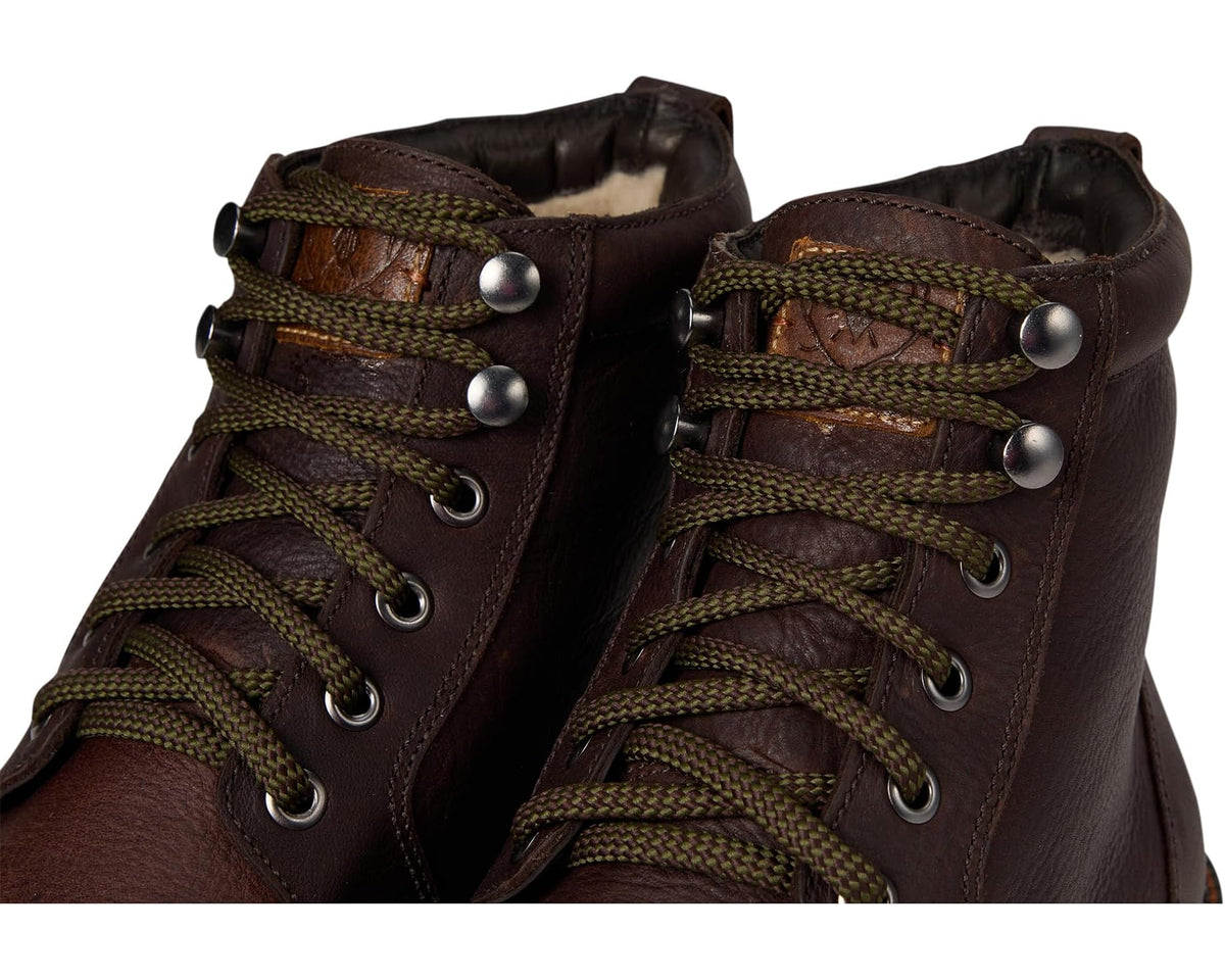 Walnut boot close-up: braided green-brown laces and metal eyelets on leather