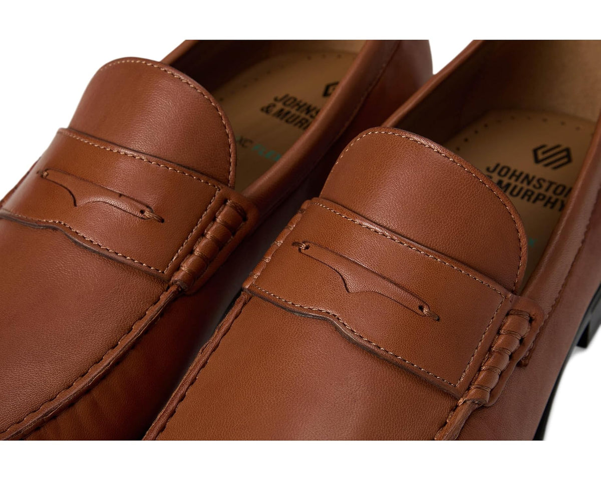 Close-up of cognac leather penny loafer upper with strap seam and stitching
