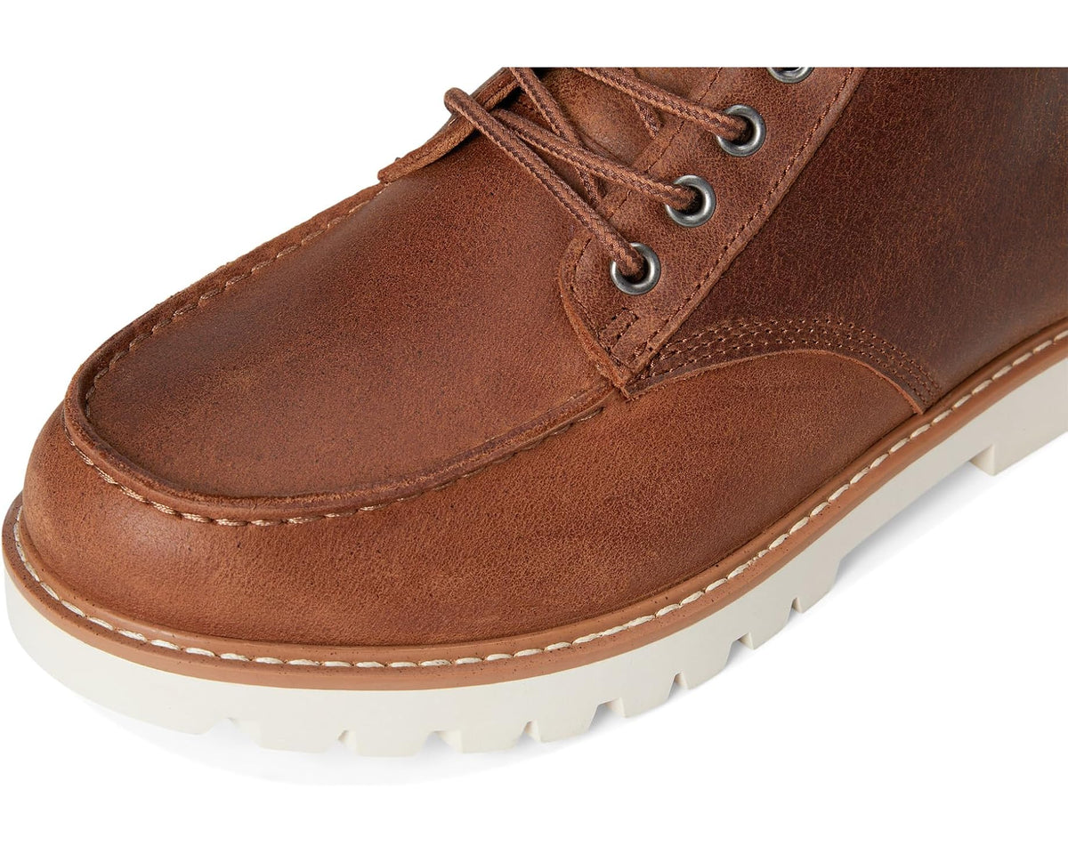 Tan leather lace-up boot toe with metal eyelets and white outsole