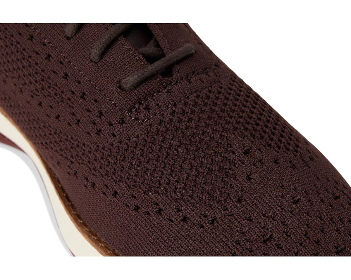 Close-up of dark brown knit upper with perforated texture and lace panel